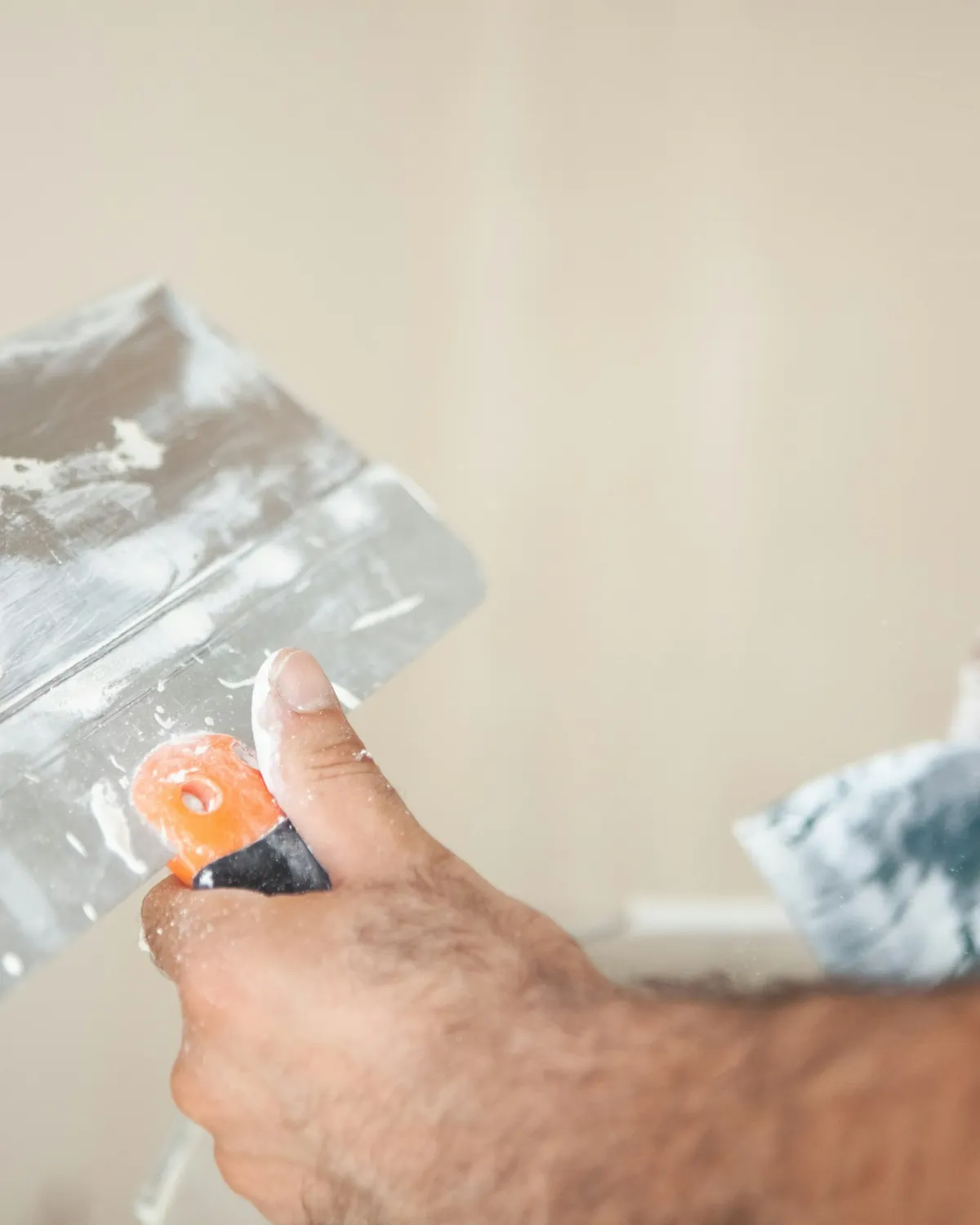Tradesman's hands finishing a wall with a trowel